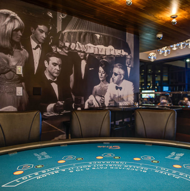 Card table with large scale throwback photo of people playing at a casino