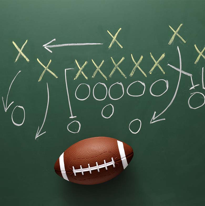 Football next to chalkboard play chart